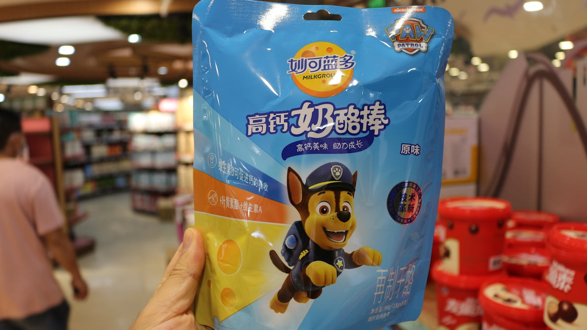 a person holding up a package of dog food in a store