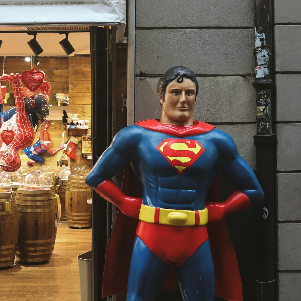a statue of a superman stands in front of a store