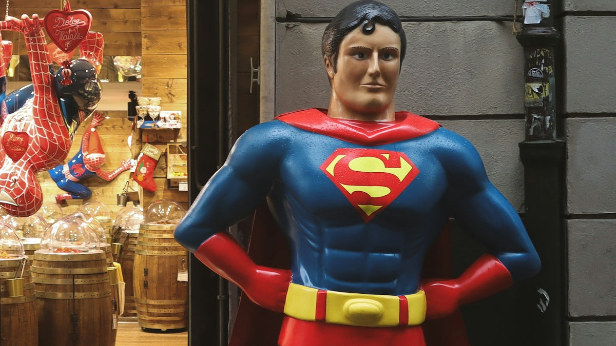 a statue of a superman stands in front of a store