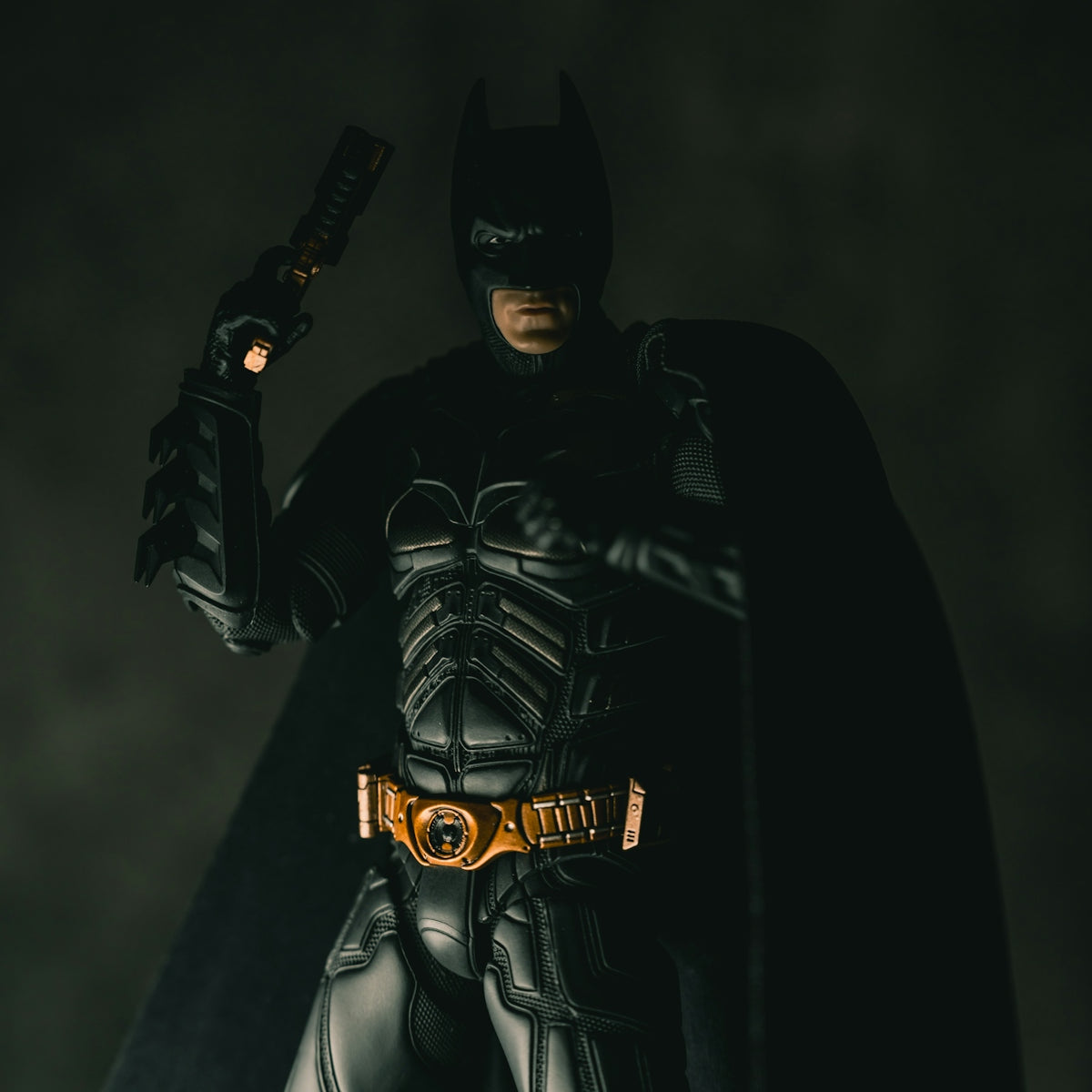 Batman holding a gun in a dark setting