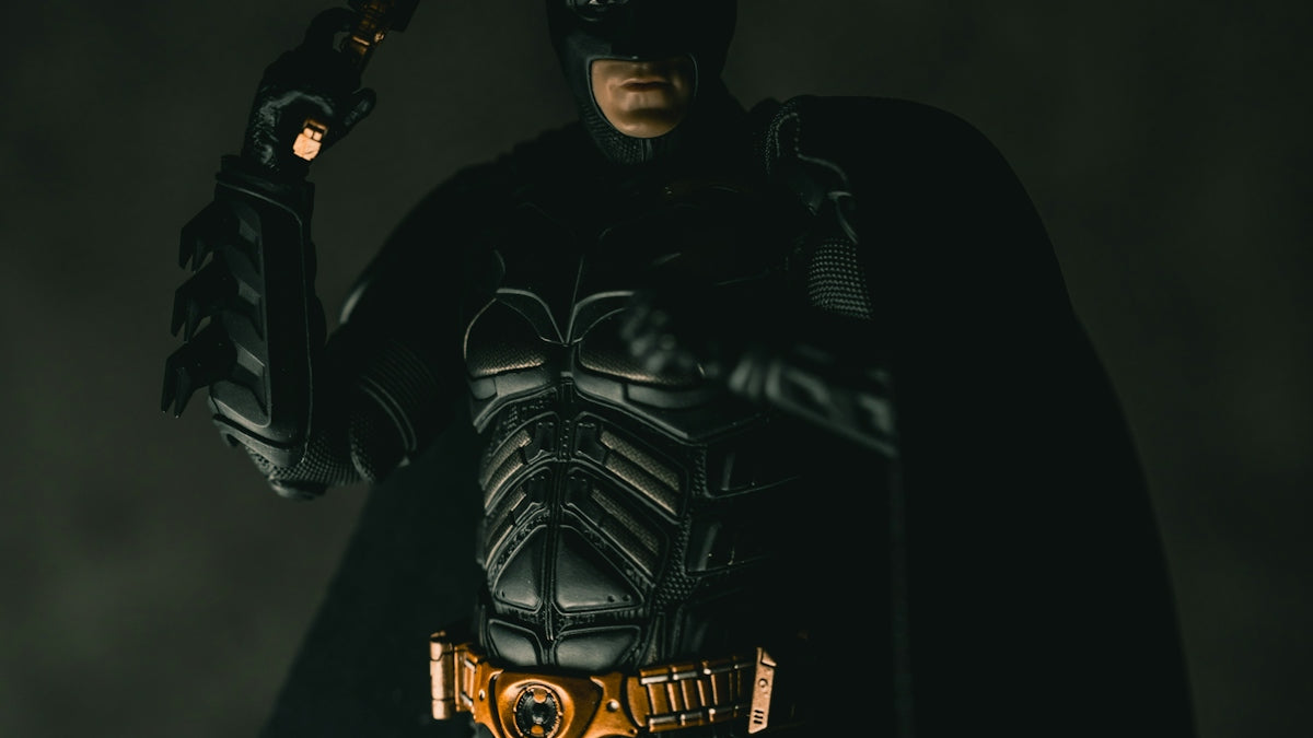 Batman holding a gun in a dark setting
