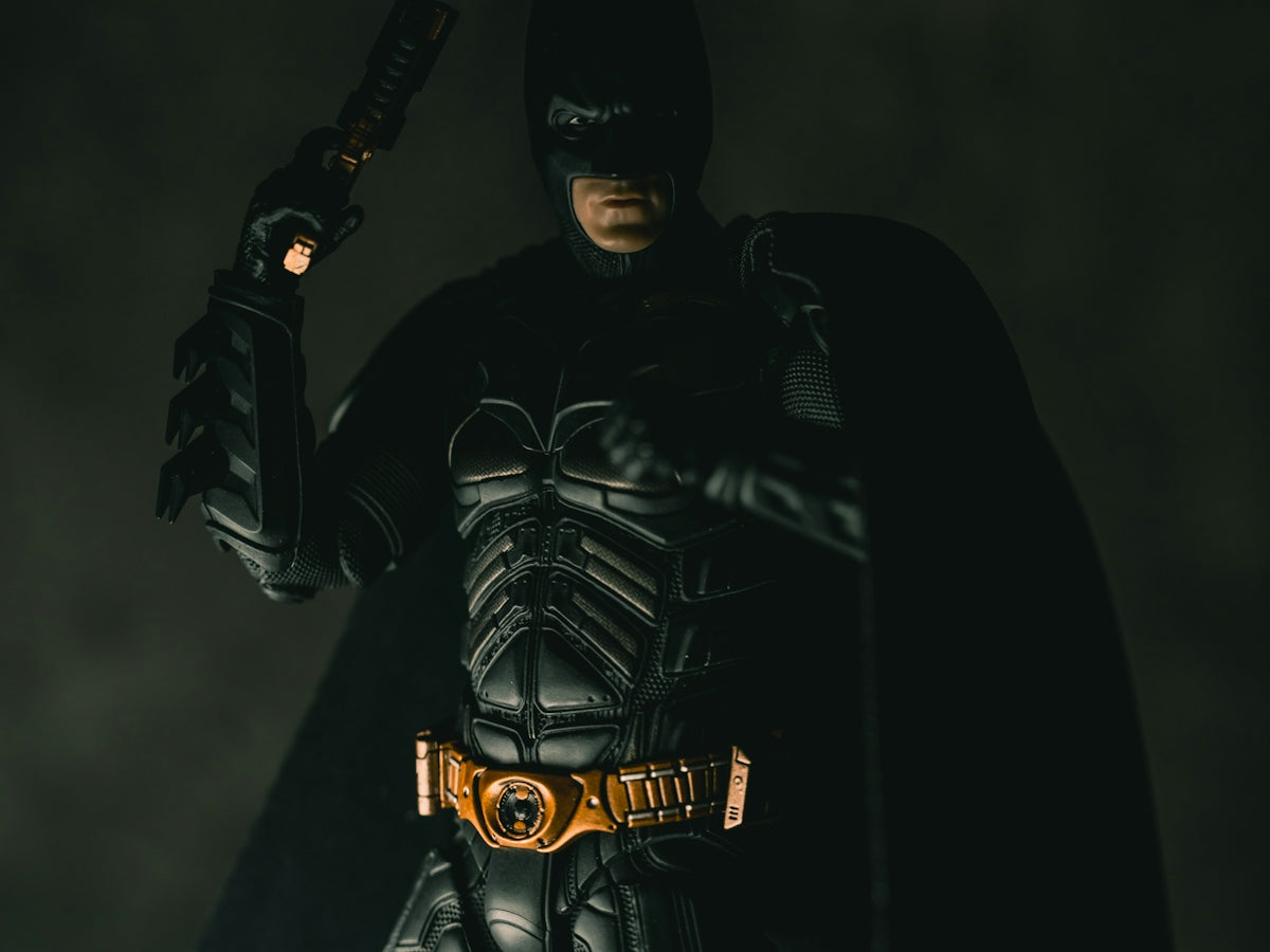 Batman holding a gun in a dark setting